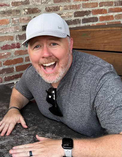 Tattoo artist creating a detailed arm tattoo using modern tools in a studio setting.